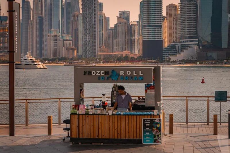 Street vendor sells ice cream by the water.